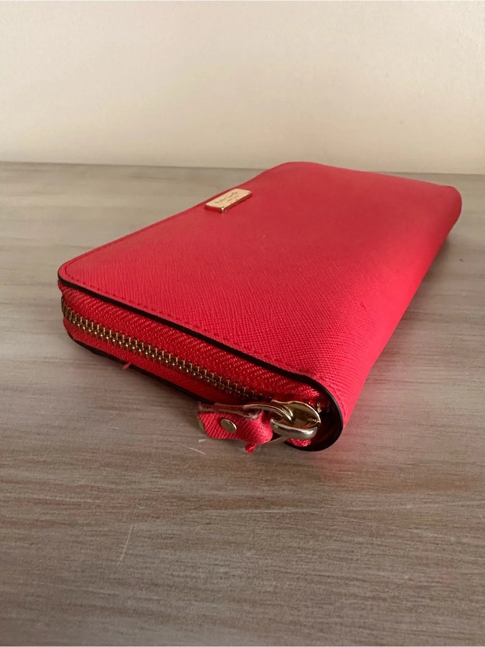 kate spade saffiano zip-around wallet in vibrant red with gold plaque
